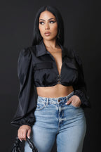 Woman wearing a black top and blue jeans against a gray background